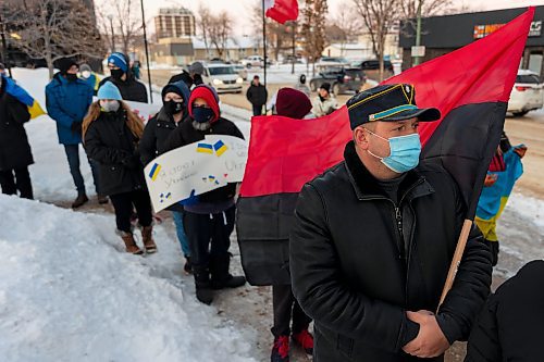 Oleksander Brianskyi, holding the Congress of Ukrainian Nationalism flag, gathers with other community members in front of Brandon City Hall Friday in support of Ukraine. (Chelsea Kemp/The Brandon Sun)