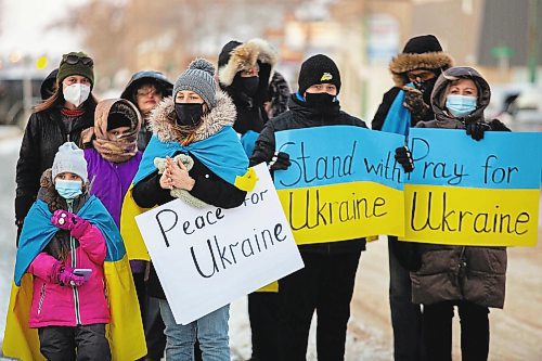 Community members gather in front of Brandon City Hall Friday in support of Ukraine. The country was invaded by Russian forces Thursday. (Chelsea Kemp/The Brandon Sun)