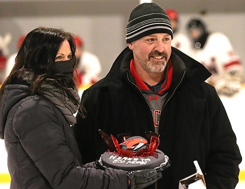 GCB Wildcats head coach Corey Forbes is presented with a cake by Angie Gudnason during a pre-game ceremony marking Forbes&#x2019; 800th game behind the bench with the Westman High School Hockey League team on Saturday at Glenboro Arena. (Perry Bergson/The Brandon Sun)