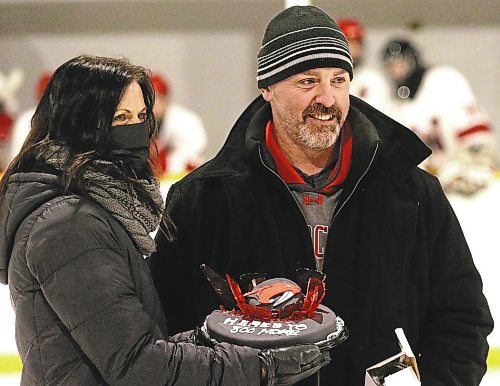 GCB Wildcats head coach Corey Forbes is presented with a cake by Angie Gudnason during a pre-game ceremony marking Forbes&#x2019; 800th game behind the bench with the Westman High School Hockey League team on Saturday at Glenboro Arena. (Perry Bergson/The Brandon Sun)