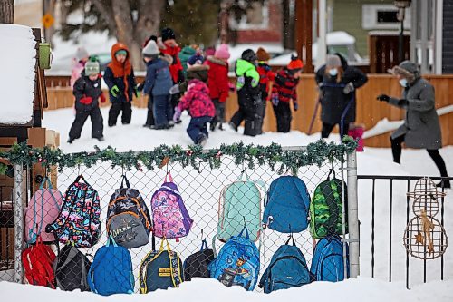 Colourful backpacks hang from a fence at Wee Wisdom Nursery School near 28th Street and Princess Avenue as children play in the snow toward the end of class Tuesday. (Tim Smith/The Brandon Sun)