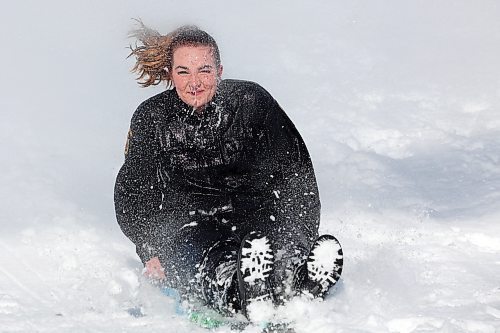 Auxiliary Const. Kiana Rose with Rivers Police Service is sprayed with a fire hose as she slides through the snow during a Polar Plunge in Rivers on Wednesday. (Photos by Tim Smith/The Brandon Sun)
