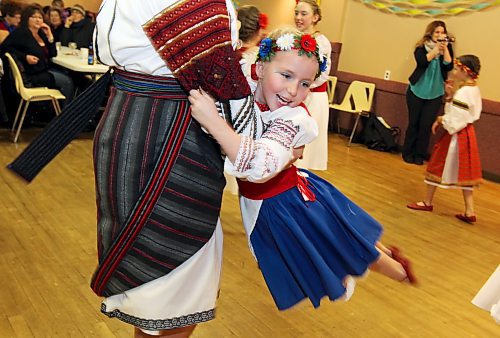 Michelle Olinyk spins Jordan Woloski as the two members of the Brandon Troyanda School of Ukrainian Dance wait between performances at the Ukrainian Pavilion during the opening night of the Lieutenant Governor's Winter Festival in 2014. (Tim Smith/Brandon Sun)