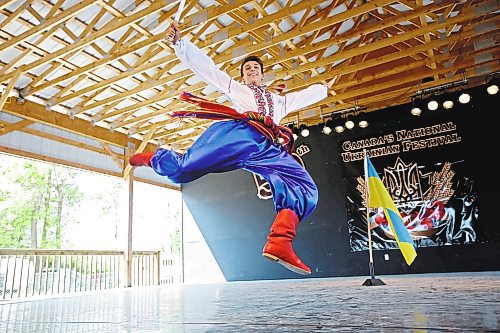 Brandon Sun  31072015 Alex Tarasenko with the Tryzub Ukrainian Dancers from Calgary leaps in the air while performing a heroic solo dance during the talent competition on the opening day of the Canadian National Ukrainian Festival at the Selo Ukraina site just outside Riding Mountain National Park south of Dauphin on Friday. This year marks the 50th anniversary of the festival. (Tim Smith/Brandon Sun)