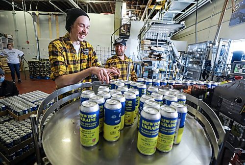 RUTH BONNEVILLE / WINNIPEG FREE PRESS



ENT - beer for Ukraine



Matthew Wolff (cap), Operations Manager at Torque Brewing, along with Kyle Maskiiw canning operator, are thrilled to start production of Ukraine Brew Friday.. Three thousand cans of the unique recipe will be produced with proceeds going to the Ukraine Crisis.  



Subject: Eight local craft breweries in Winnipeg are collaborating on a beer, with all proceeds going to a humanitarian relief fund in Ukraine. The beer recipe is from Pravda Brewing, a Ukrainian brewery based in Lviv.



The breweries collaborating are: Torque Brewing, Trans Canada Brewing, Nonsuch Brewing, Barn Hammer Brewing, One Great City Brewing, Devil May Care Brewing, Lake of the Woods Brewing, and Stone Angel Brewing.



Eva Wasney







April 8th,  2022