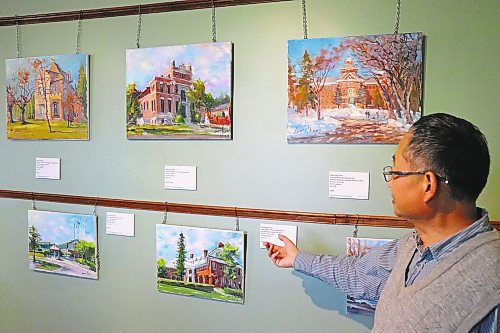 Weiming Zhao showcases some of the oil paintings that are currently on display at the Daly House Museum as a part of his new &quot;Brandon Heritage en Plein Air&quot; exhibition. This solo show is scheduled to run until Sept. 30, with Zhao also planning to take part in an open house on April 23. (Kyle Darbyson/The Brandon Sun) 