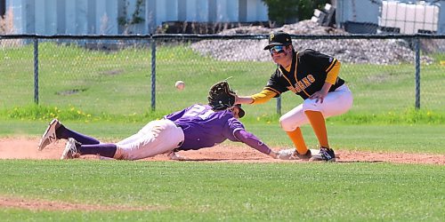 Vincent Massey Vikings baserunner Jayce Thompson (21) dives safely back to the bag as Portage Trojans first baseman Kade Maryniuk (11) prepares to catch the ball during quarterfinal action at the high school provincial baseball championship at Sumner Field on Friday afternoon. Portage won 19-9 in a game that ended after five innings due to the mercy rule. (Perry Bergson/The Brandon Sun)
