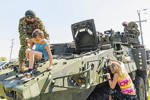 Stefan Eberts, 7, climbs out of a Light Armoured Vehicle with help from Pte. Felix Louselle during Touch-a-Truck at the Keystone Centre grounds Saturday. (Photos by Chelsea Kemp/The Brandon Sun)