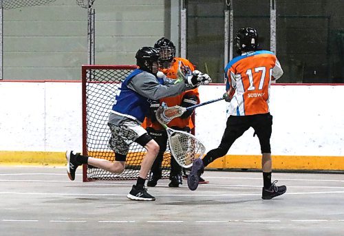 Cash Zdan of the Wheat City Wranglers gets hit by the ball as he defends goalie Mason Woychyshyn from a shot by Madden Lavergne of the Carberry Crush in an under-14 game at Flynn Arena on Saturday morning. Carberry won 4-2. Watch The Brandon Sun for a story later this week on the Westman lacrosse scene. (Perry Bergson/The Brandon Sun)