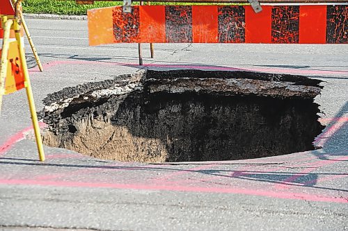 ETHAN CAIRNS / WINNIPEG FREE PRESS

A large sinkhole opened in the middle of the intersection of St. Matthews Ave. And Spruce st. in Winnipeg on Tuesday, July 26, 2022