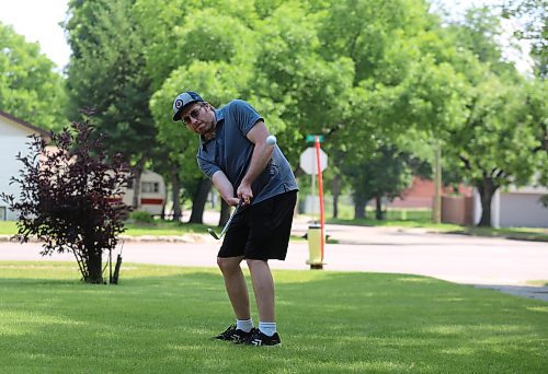 Tyler McDonald practices his chipping on his front lawn on a sunny Tuesday afternoon. (Drew May/The Brandon Sun)