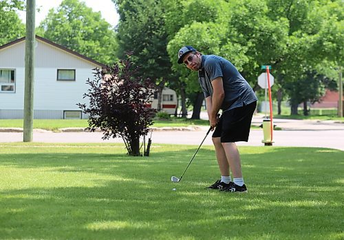 Tyler McDonald lines up a shot on his front lawn on a sunny Tuesday afternoon. (Drew May/The Brandon Sun)