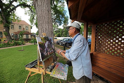 Brandon painter Weiming Zhao paints a scene at the Daly House on Wednesday morning during Brandon Downtown Ambassadors' Tea at the Daly House event. (Drew May/The Brandon Sun)