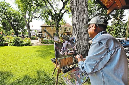 Brandon painter Weiming Zhao paints a scene at the Daly House on Wednesday morning during Brandon Downtown Ambassadors' Tea at the Daly House event. (Drew May/The Brandon Sun)