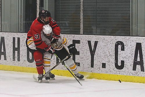Kenora Thistles captain Emerson Evans (23) ties up Brandon Wheat Kings forward Brady Turko behind the Kenora net during the first period of their Manitoba U18 AAA Hockey League game at J&amp;G Homes Arena on Sunday afternoon. (Perry Bergson/The Brandon Sun)
