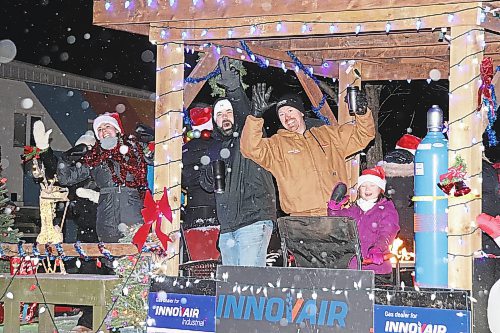 Representatives of Innovair Industrial drink in the jubilant, holiday-themed atmosphere that was in heavy supply during Saturday's Brandon Santa Parade. (Kyle Darbyson/The Brandon Sun)