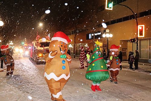 Local residents line up on both sides of Rosser Avenue Saturday night to watch the 2022 Brandon Santa Parade, which featured all manner of holiday-themed floats and mascots handing out candy and high fives. This year's parade, the first since 2019, featured around 45 floats and countless other accompanying vehicles according to event organizers. (Kyle Darbyson/The Brandon Sun)