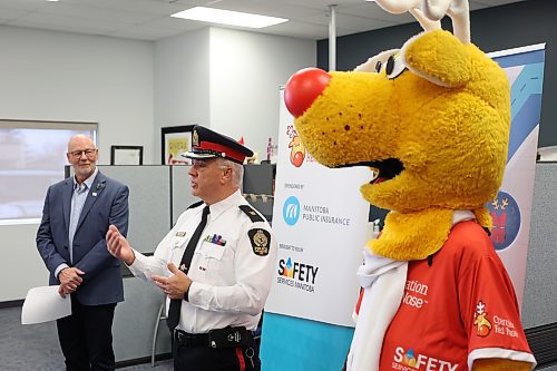 Brandon Police Service Inspector Marc Alain, flanked by Ron Janzen of Safety Services Manitoba (left) and the Operation Red Nose mascot (right), speaks during the kickoff for the annual Operation Red Nose program at the Brandon CAA office on 18th Street North on Monday. (Tim Smith/The Brandon Sun)