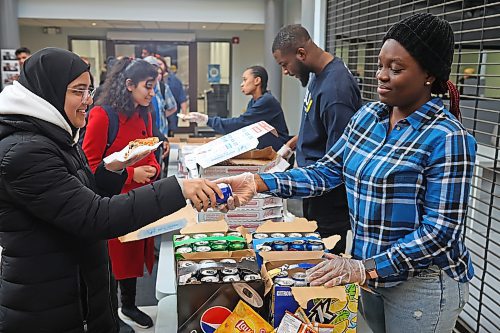 Tolulope Oke, International Student director with the Brandon University Student Union, works alongside fellow union members to distribute free pizza, drinks and snacks to BU students on their last day of classes for the fall semester on Tuesday. (Tim Smith/The Brandon Sun)
 