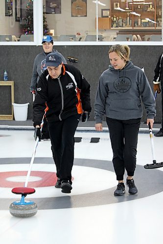 Scott Madder, left, gets pointers from coach Darla Cunningham as he delivers a rock during a Special Olympics curling session at the Riverview Curling Club on Nov. 27. (Lucas Punkari/The Brandon Sun)