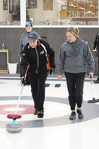Scott Madder, left, gets pointers from coach Darla Cunningham as he delivers a rock during a Special Olympics curling session at the Riverview Curling Club on Nov. 27. (Lucas Punkari/The Brandon Sun)
