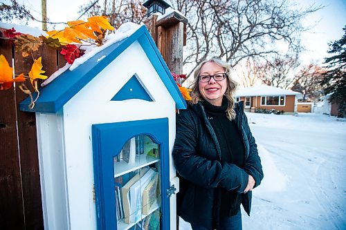 MIKAELA MACKENZIE / WINNIPEG FREE PRESS

Lisa Feyereisen poses for a photo with her little free library on Rossmere Crescent  in Winnipeg on Wednesday, Dec. 7, 2022. For Rachel story.
Winnipeg Free Press 2022.