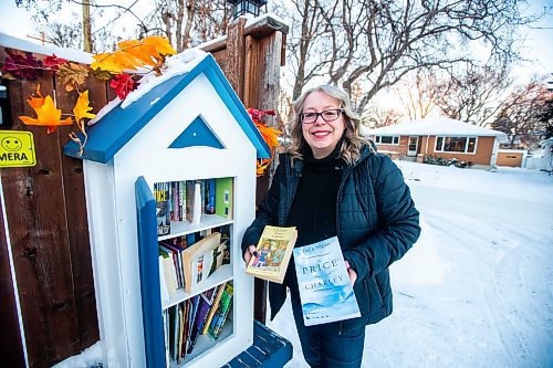 MIKAELA MACKENZIE / WINNIPEG FREE PRESS

Lisa Feyereisen poses for a photo with her little free library on Rossmere Crescent  in Winnipeg on Wednesday, Dec. 7, 2022. For Rachel story.
Winnipeg Free Press 2022.