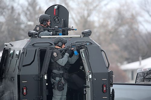 Brandon Sun Brandon Police Service officers point their firearms at a house on Cascade Bay on Tuesday morning as part of a training exercise`. There were no details immediately available on the training, but several officers were sitting in the vehicle. (Drew May/The Brandon Sun)