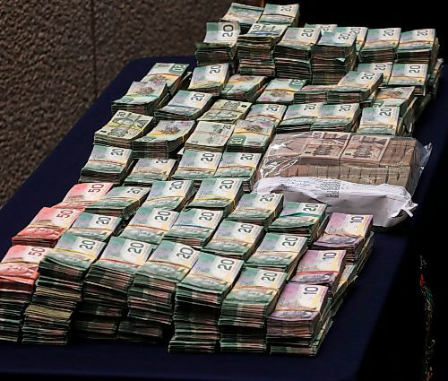 Police Display cash -A police traffic stop has resulted in the forfeiture  of $960,000 that will be used by law enforcement and victim services  under the Criminal Forfeiture Fund  as announced by Justice Minister Andrew Swan at RCMP HQ in Wpg .Mar. 24 2014 / KEN GIGLIOTTI / WINNIPEG FREE PRESS