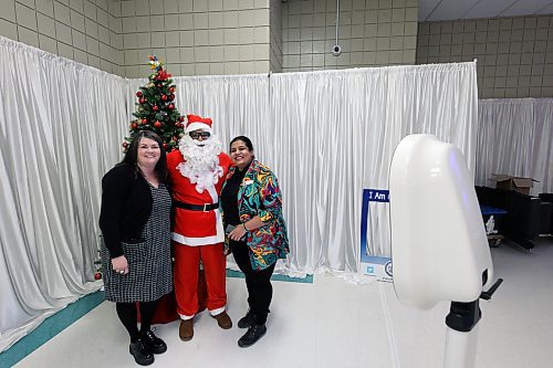 Sarah Ferguson (left) and Archana Krishnan (right) of Westoba Credit Union snap a picture with Santa at a selfie station set up by Trident Films at Thursday's Brandon Chamber of Commerce luncheon. (Colin Slark/The Brandon Sun)