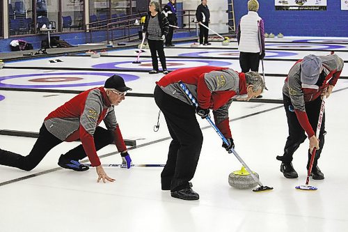Skip Dale Brooks watches on as lead Don Williams and second Tim Weber sweep a rock during Thursday's Westoba Credit Union Masters Super League at the Brandon Curling Club. (Lucas Punkari/The Brandon Sun)