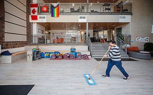 MIKE DEAL / WINNIPEG FREE PRESS
Custodian, Erik De Los Rios sweeps the floor of the atrium where the water from the second floor music room cascaded down onto the main floor last night.
A sprinkler in Westgate Mennonite Collegiate went off mistakenly last night and flooded several rooms, including the Music Room, Library and the atrium. Historic choral papers, from the very beginning of the school's history in 1958, have been destroyed. The music teachers are devastated - as are the administrators and families. The school prides itself on being a music powerhouse, with choir mandatory for all G6-9 students, and optional - although many students take it - in 10-12. 
See Maggie Macintosh story 
221208 - Thursday, December 08, 2022.