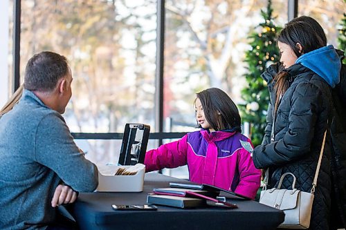 MIKAELA MACKENZIE / WINNIPEG FREE PRESS

Emma Poon (six) exchanges money for a new two dollar coin commemorating Queen Elizabeth at the Royal Canadian Mint in Winnipeg on Thursday, Dec. 8, 2022. For Shauna story.
Winnipeg Free Press 2022.