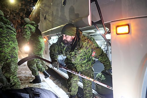 08122022
Soldiers with 2nd Battalion, Princess Patricia's Canadian Light Infantry and 1st Regiment, Royal Canadian Horse Artillery grab their personal belongings from the bus after arriving back to CFB Shilo from Latvia late Thursday night following a six month deployment as part of Operation Reassurance. Over 500 troops have been returning home from Shilo over the past few weeks with approximately 120 arriving home Thursday. Other troops from Shilo deployed to Latvia in recent days as part of the ongoing operation. 
(Tim Smith/The Brandon Sun)