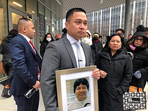 ERIK PINDERA / WINNIPEG FREE PRESS

Edward Balaquit holds a photograph of his father, Eduardo Balaquit, outside Winnipeg&#x2019;s courthouse on Wednesday, while mother and widow Illuminada stands to the right. November 9, 2022
