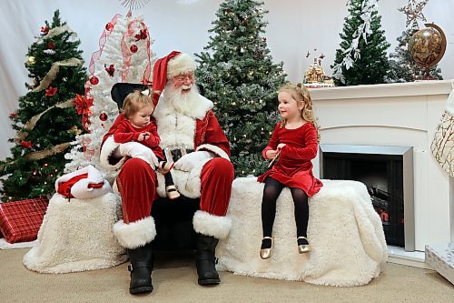 Sisters Shayne and Finleigh Balcaen-Drier visit with Santa Claus, aka Klaus Brechmann, at Santa Photo Central by Champion Digital at The Town Centre on Thursday afternoon. Owner and photographer Amber White has been taking bookings for photos with Santa since November 12. Santa Photo Central is booking sessions until Dec. 23. White has been running Santa Photo Central yearly since 2001 except for 2020, when businesses were closed during the COVID-19 pandemic. Brechmann has been playing Santa for more than 40 years. (Tim Smith/The Brandon Sun)