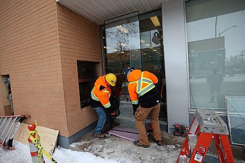 Workers with Horizon Glass replace a broken window at The Town Centre in Brandon on a mind Thursday. (Tim Smith/The Brandon Sun)