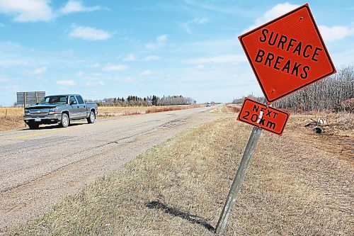 A pickup truck travels along Provincial Road 353, north of Brandon, past a sign warning of the poor road conditions, in this file image. (File/The Brandon Sun)
