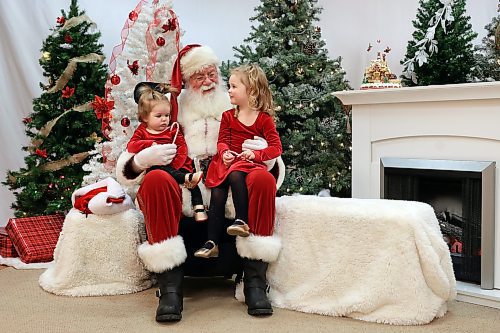 15122022
Sisters Shayne and Finleigh Balcaen-Drier visit with Santa Claus, aka Klaus Brechmann, at Santa Photo Central by Champion Digital at The Town Centre on Thursday afternoon. Owner and photographer Amber White has been taking bookings for photos with Santa since November 12. Santa Photo Central is booking sessions until December 23. White has been running Santa Photo Central yearly since 2001 except for 2020 when businesses were closed during the COVID-19 pandemic. Brechmann has been playing Santa for over 40 years. (Tim Smith/The Brandon Sun)