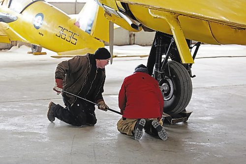 Commonwealth Air Training Plan Museum board president John McNarry (left) and vice-president Art Brown adjust a skate attached to the wheel of a Bristol Bolingbroke aircraft so it can be moved to make room for temporary repairs to the historic hangar on Friday morning. (Colin Slark/The Brandon Sun)