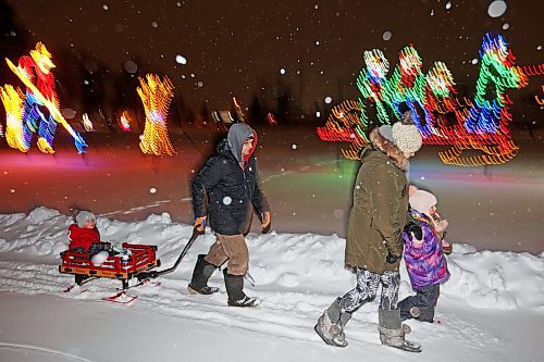 Dustin Troop and Crystal Donley enjoy a family walk through the snow with their children Ashton and Tayleah at the Brandon skating oval on a snowy Friday evening. (Tim Smith/The Brandon Sun)