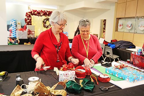 Yvette Lennon and Donna Staples volunteers with CNIB are all smiles as they wrap presents. The gift wrap station is open until Dec. 24 during Brandon Shoppers Mall regular hours of operation. The cost to have gifts wrapped is a donation of your choice to the CNIB. (Michele McDougall/The Brandon Sun)