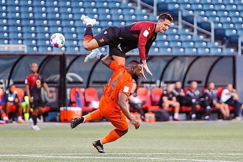 Daniel Crump / Winnipeg Free Press. A Valour FC player collides with Forge FC defender Dominic Samuel (4) during play at IG Field in Winnipeg. August 31, 2022.