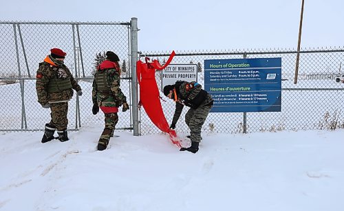 RUTH BONNEVILLE / WINNIPEG FREE PRESS
Local - Brady Landfill closed
A group supporting search efforts for remains of murdered women talk to media as they continue their encampment at entrance to Brady Road landfill gates Monday.
The city tweeted saying the landfill is closed today (it was closed yesterday as well).
Tray DeLaronde (right) and Taylor Orpin (middle) adjust red dress hanging on fence Monday. Supporter, Tom McNeil (right), was also present in this photo.
See Chris Kitching story.
Dec 19th, 2022
