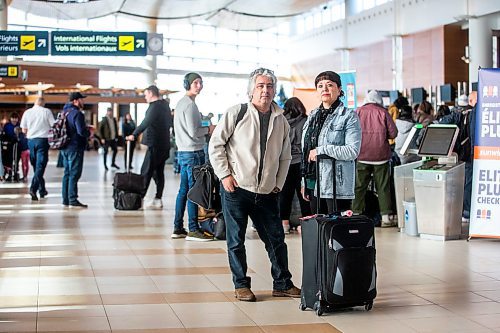 MIKAELA MACKENZIE / WINNIPEG FREE PRESS

Dave Wilder and Karin Phillips, who are stuck in Winnipeg when they should be on their honeymoon due to a flight cancellation, pose for a photo while waiting at the airport in Winnipeg on Tuesday, Dec. 20, 2022.  For Kevin Rollason story.
Winnipeg Free Press 2022.