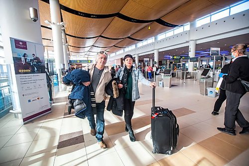 MIKAELA MACKENZIE / WINNIPEG FREE PRESS

Dave Wilder and Karin Phillips, who are stuck in Winnipeg when they should be on their honeymoon due to a flight cancellation, pose for a photo while waiting at the airport in Winnipeg on Tuesday, Dec. 20, 2022.  For Kevin Rollason story.
Winnipeg Free Press 2022.