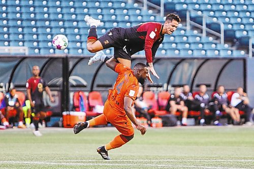 Daniel Crump / Winnipeg Free Press. A Valour FC player collides with Forge FC defender Dominic Samuel (4) during play at IG Field in Winnipeg. August 31, 2022.