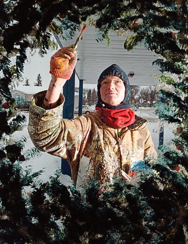 Artist Anne Boychuk fills in a holiday wreath on the window of a Brandon, Man., business Wednesday afternoon November 29, 2000. Boychuk is busy painting holiday-themed scenes on the windows of businesses gearing up for Christmas. (CP PHOTO/Brandon Sun-Colin Corneau)