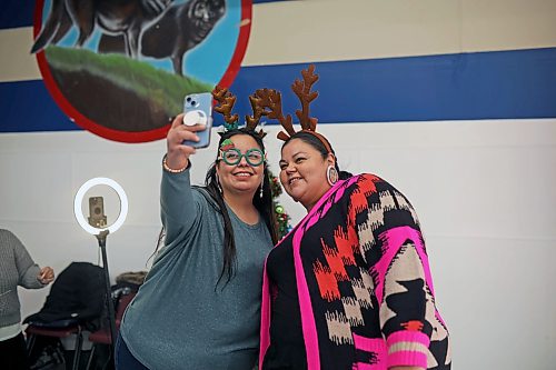 Sisters Teresa and Kimberley McKay take a selfie wearing festive props during the Christmas dinner at the Sioux Valley Dakota Nation Veterans Hall on Thursday evening. (Tim Smith/The Brandon Sun)
