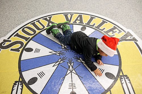 Three-year-old Tatanka Ska Mani Hoksida plays on the Sioux Valley Dakota Nation crest during the Christmas dinner at the SVDN Veterans Hall on Thursday evening. (Tim Smith/The Brandon Sun)